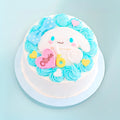 A round white cake decorated with light blue rosette frosting, a large white bunny face, a blue bow, a pink heart-shaped plaque reading 'Olivia', and yellow heart accents, shown on a light blue background.